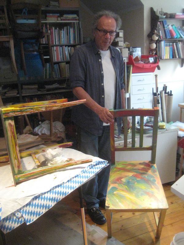 Claus Fettweiss und seine individuell bemalten Stühle Claus Fettweiss mit einem farbig gestalteten Holzstuhl in seiner Werkstatt